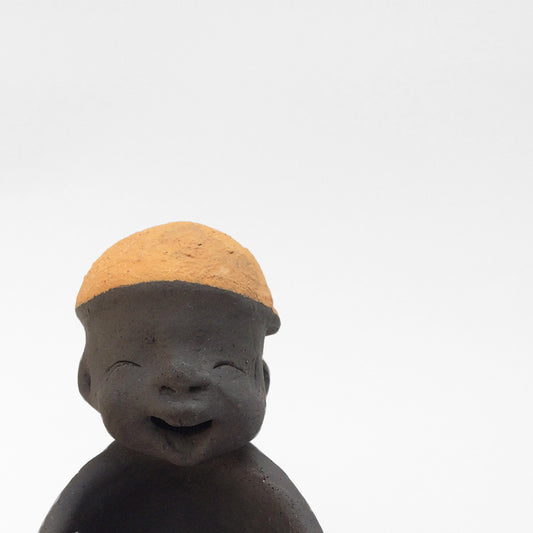 Dark grey ceramic figurine with orange cap.