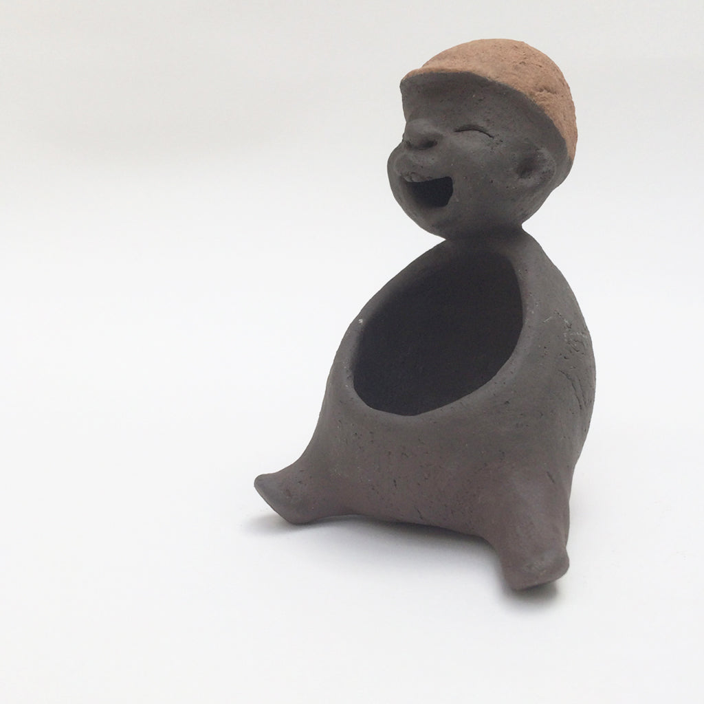 Dark grey ceramic figurine with brown cap.