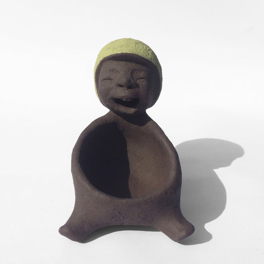 Dark grey ceramic figurine with green helmet.