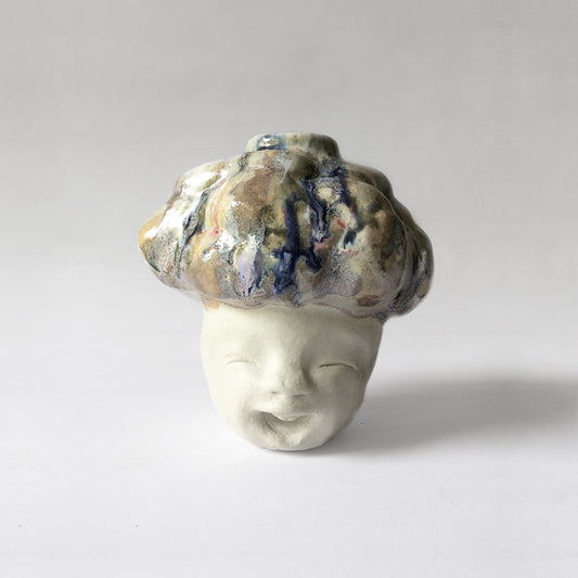 White figurative ceramic sculpture with abstract purple glazed facing front.