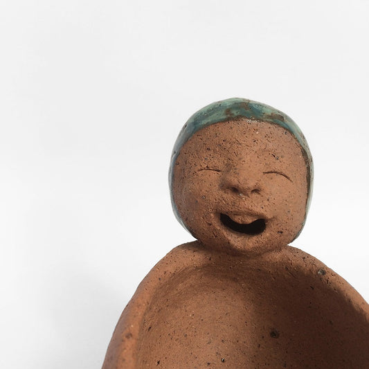 Brown unglazed figurative ceramic object with speckle glazed accent on top