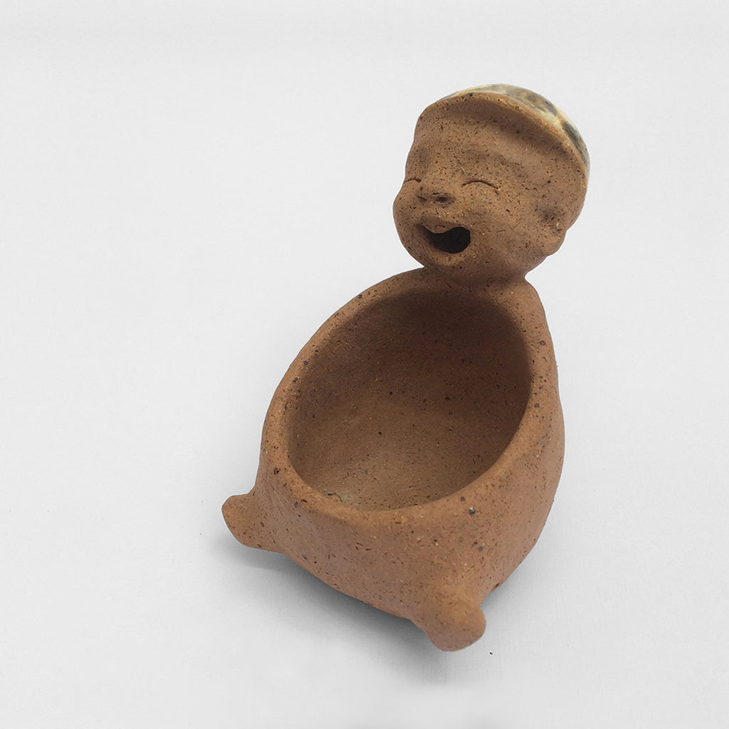 Brown unglazed ceramic object with speckle glazed accent on top.