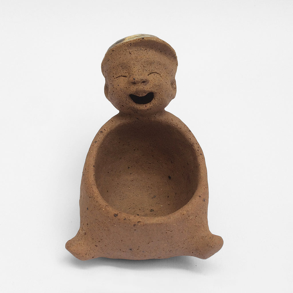 Brown unglazed ceramic object with speckle glazed accent on top.