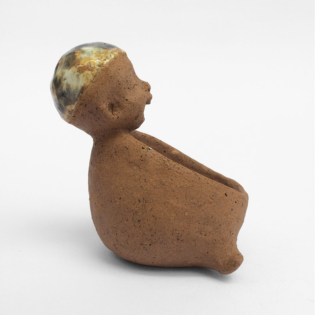 Brown unglazed figurative ceramic object with speckle glazed accent on top