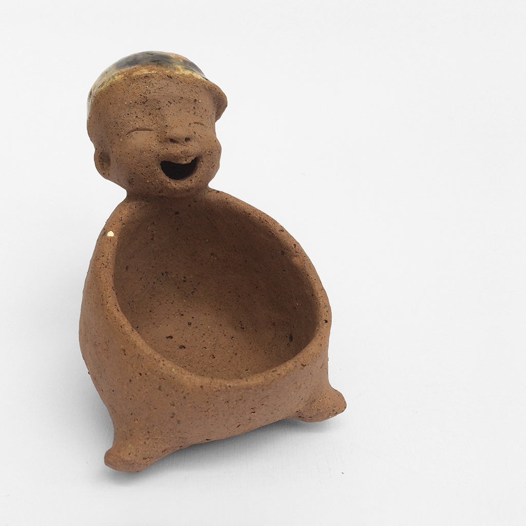 Brown unglazed figurative ceramic object with speckle glazed accent on top