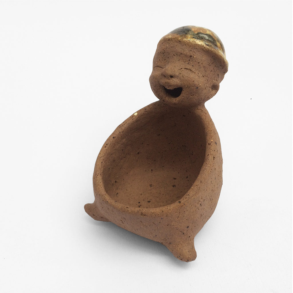 Brown unglazed figurative ceramic object with speckle glazed accent on top