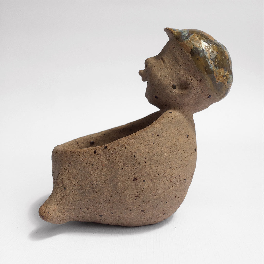 Brown unglazed figurative ceramic object with speckle glazed accent on top