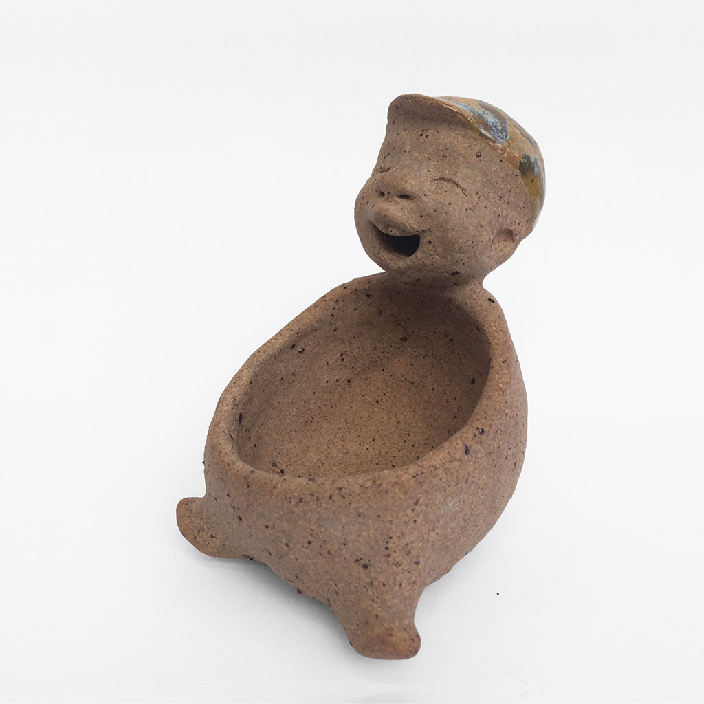 Brown unglazed figurative ceramic object with speckle glazed accent on top