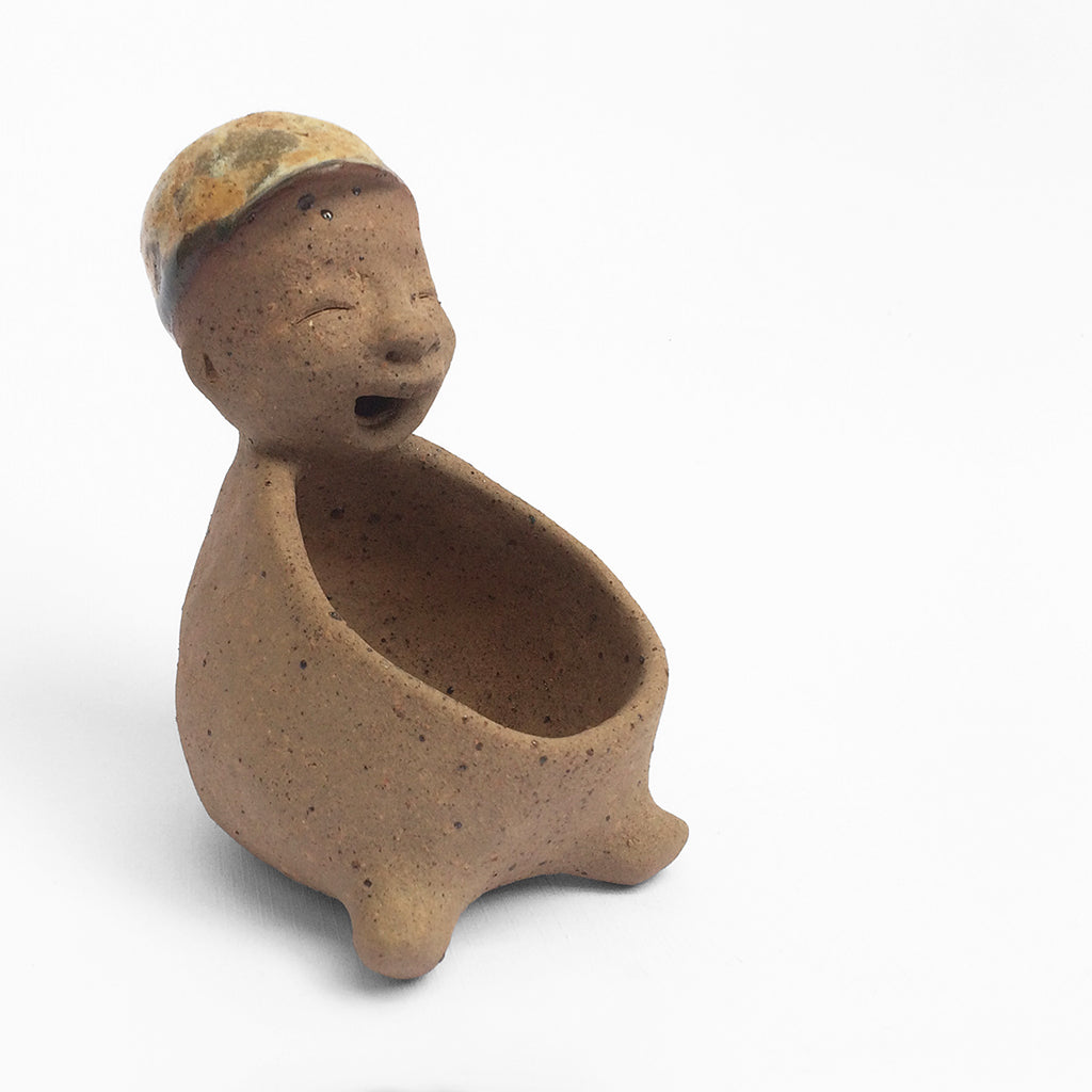Brown unglazed figurative ceramic object with speckle glazed accent on top