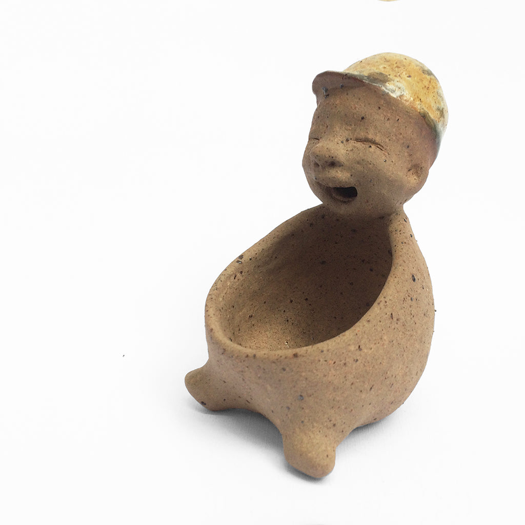 Brown unglazed figurative ceramic object with speckle glazed accent on top