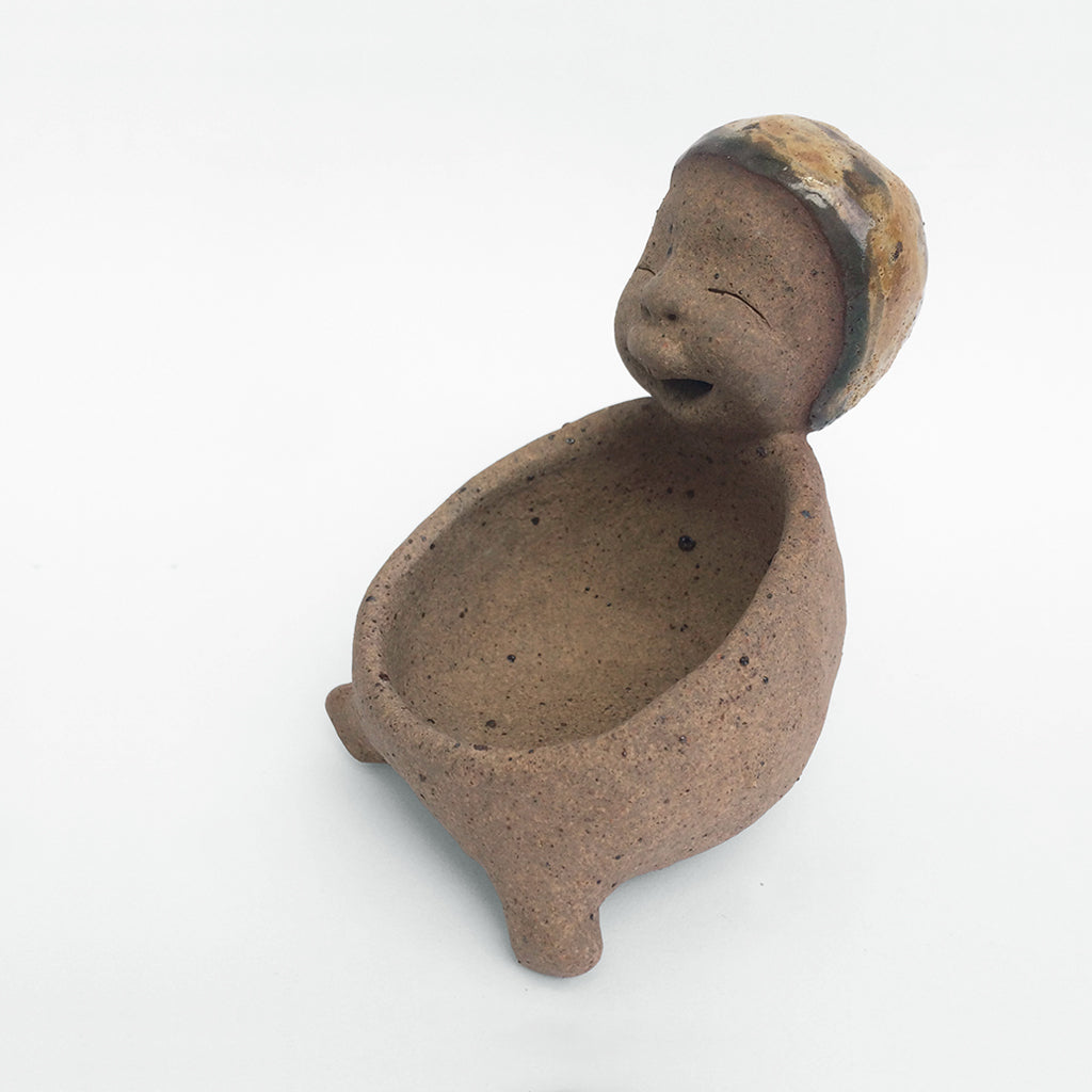 Brown unglazed figurative ceramic object with speckle glazed accent on top.