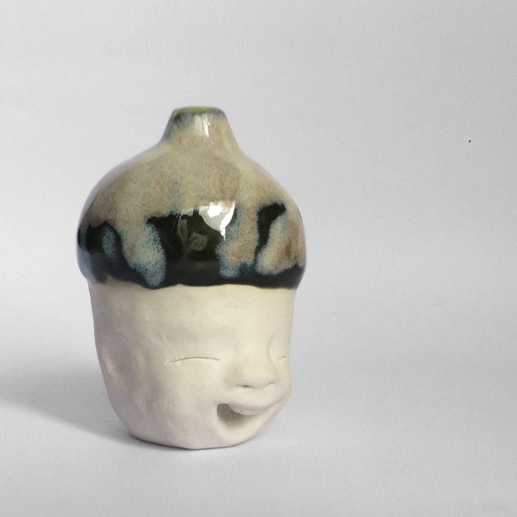 White figurative ceramic sculpture with mixed glazed head facing right.