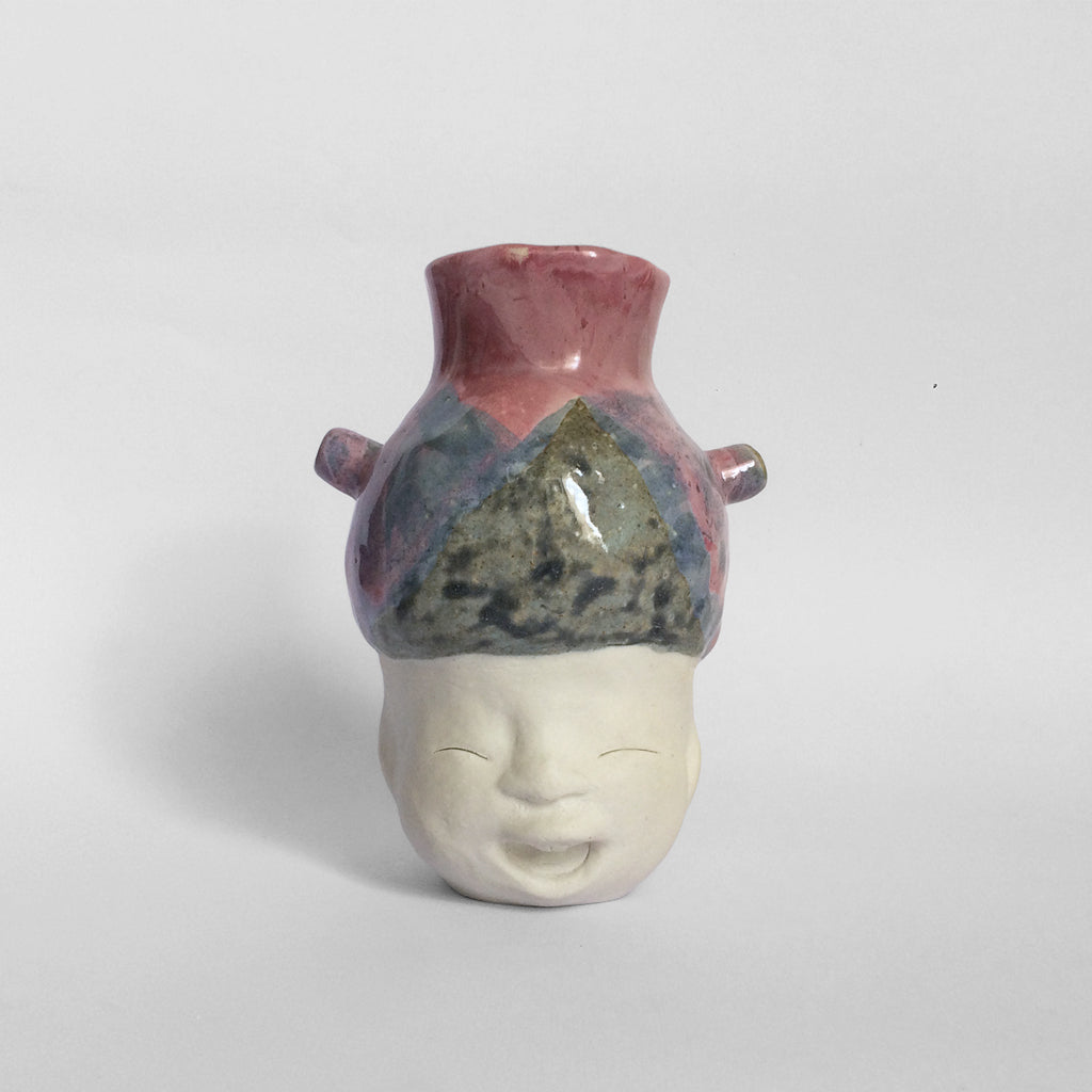 White figurative ceramic sculpture with mixed glazed head facing front.