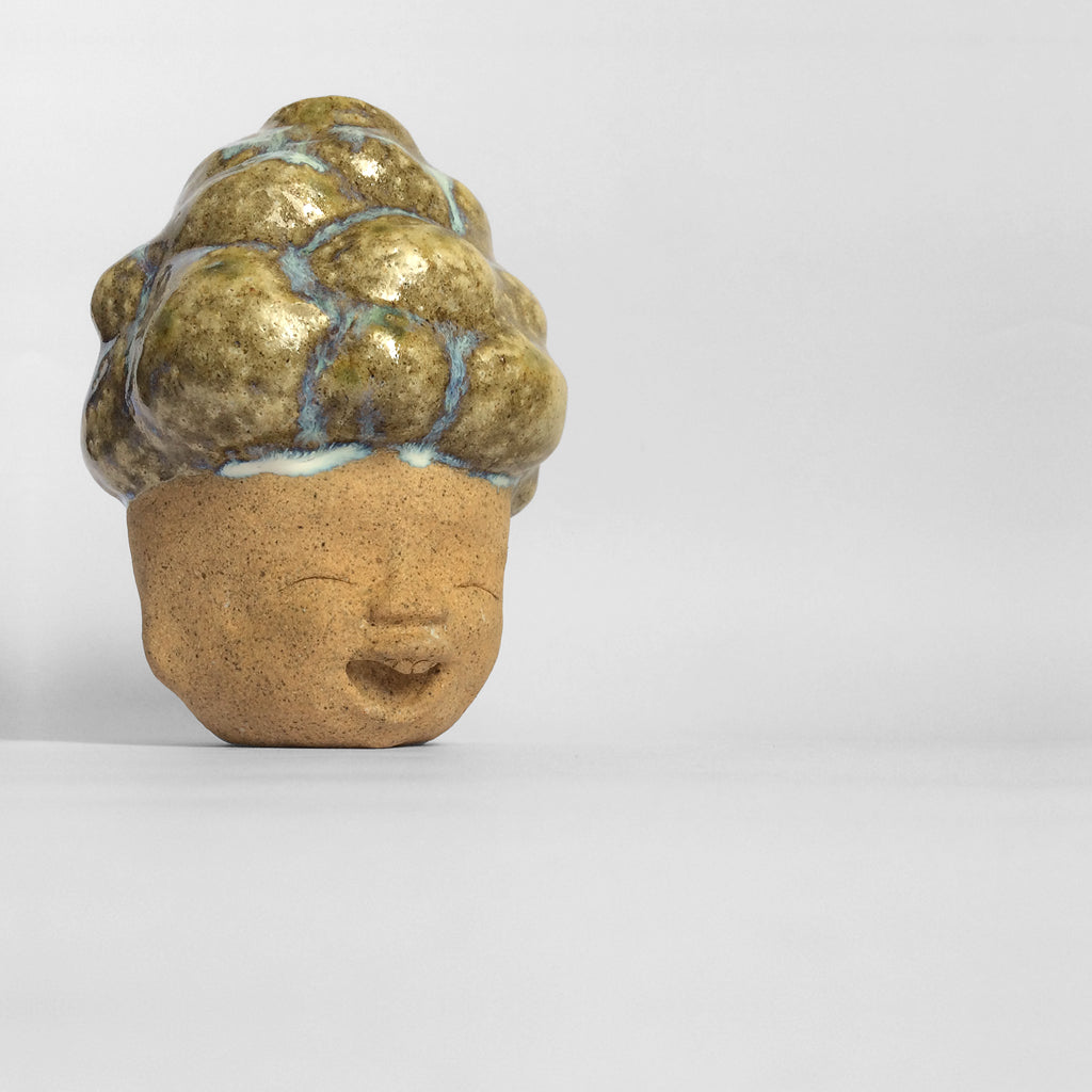 Brown figurative ceramic sculpture with brown glazed head facing right.