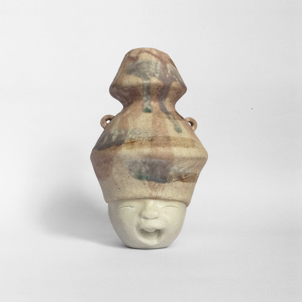 White figurative ceramic sculpture with mixed glazed head facing front.