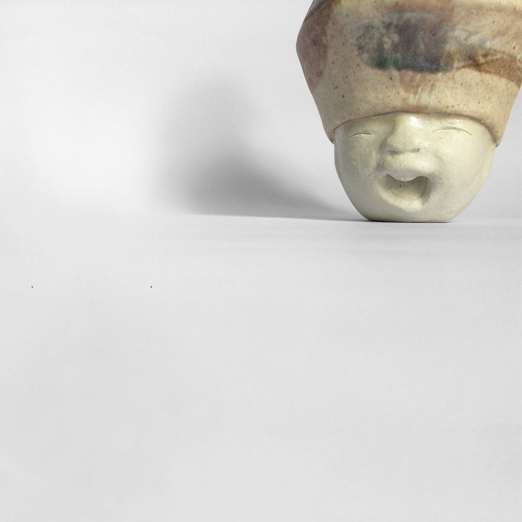 White figurative ceramic sculpture with mixed glazed head.