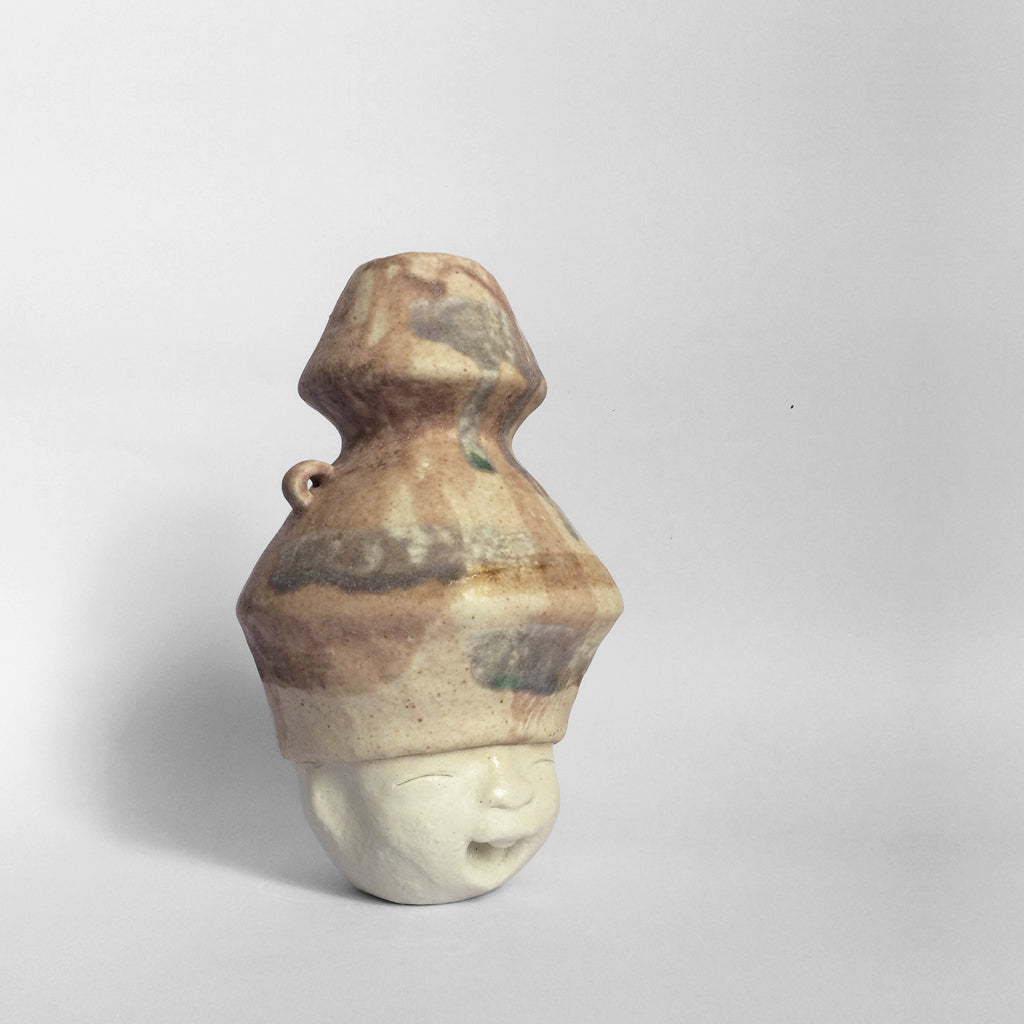 White figurative ceramic sculpture with mixed glazed head facing right.