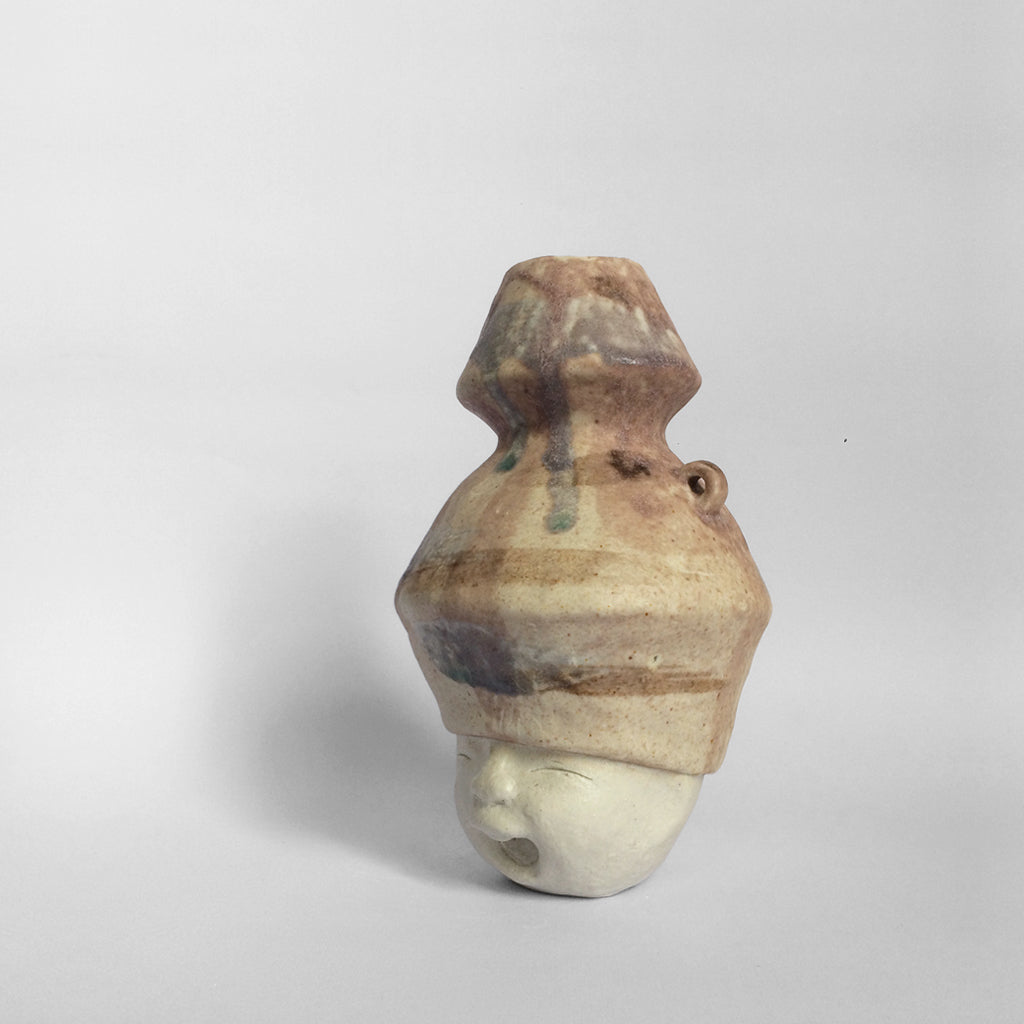 White figurative ceramic sculpture with mixed glazed head facing left.