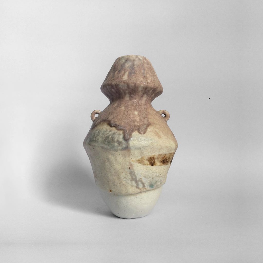 White figurative ceramic sculpture with mixed glazed head facing back.