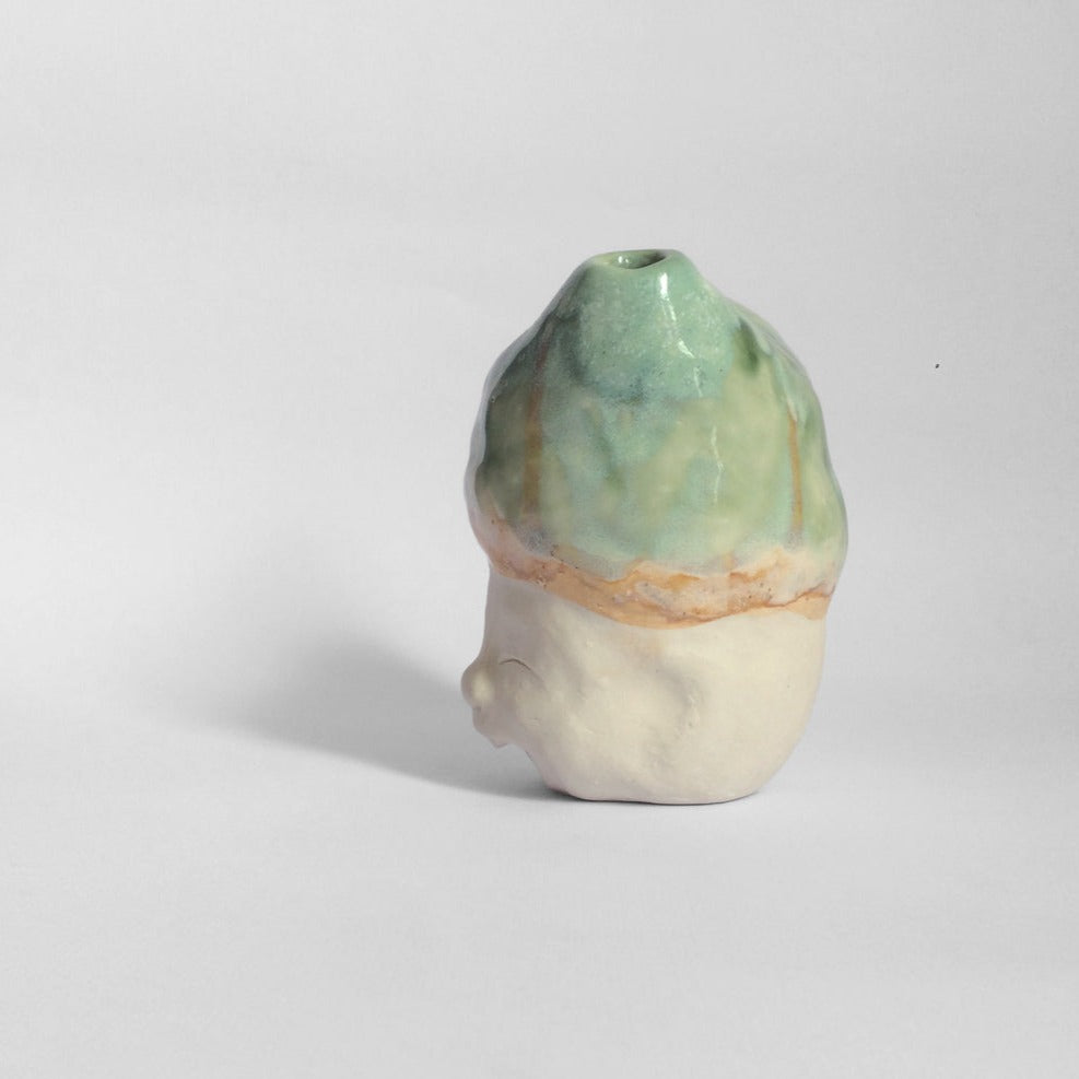 White figurative sculpture with mixed glazed head facing left.