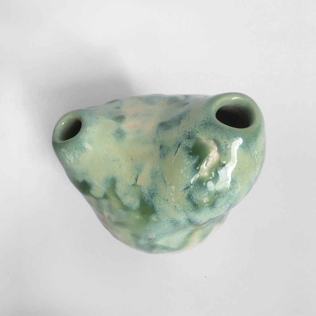 White figurative sculpture with mixed glazed head from top.