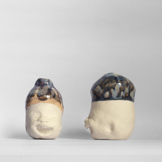 two white figurative sculptures with dark blue glazed head.