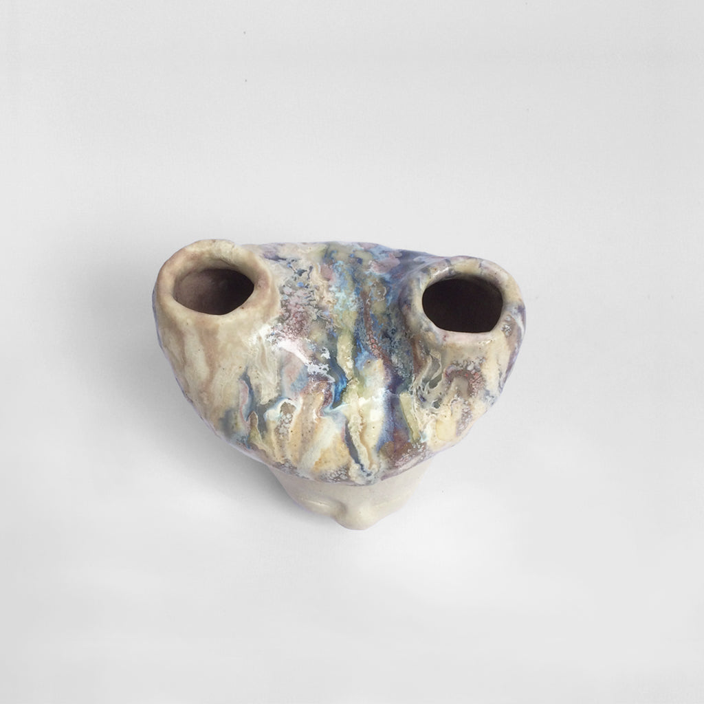 White figurative ceramic sculpture with abstract purple glazed head  from above.