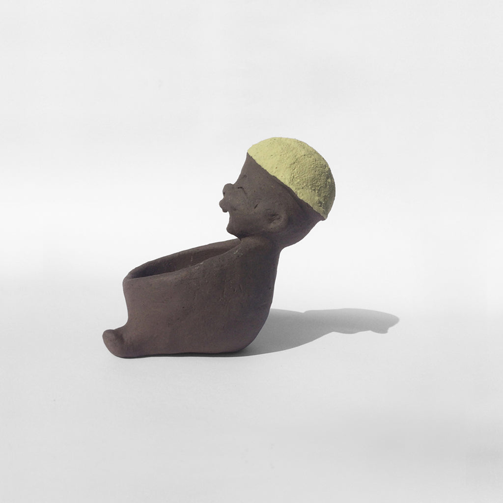 grey ceramic figurine with green cap
