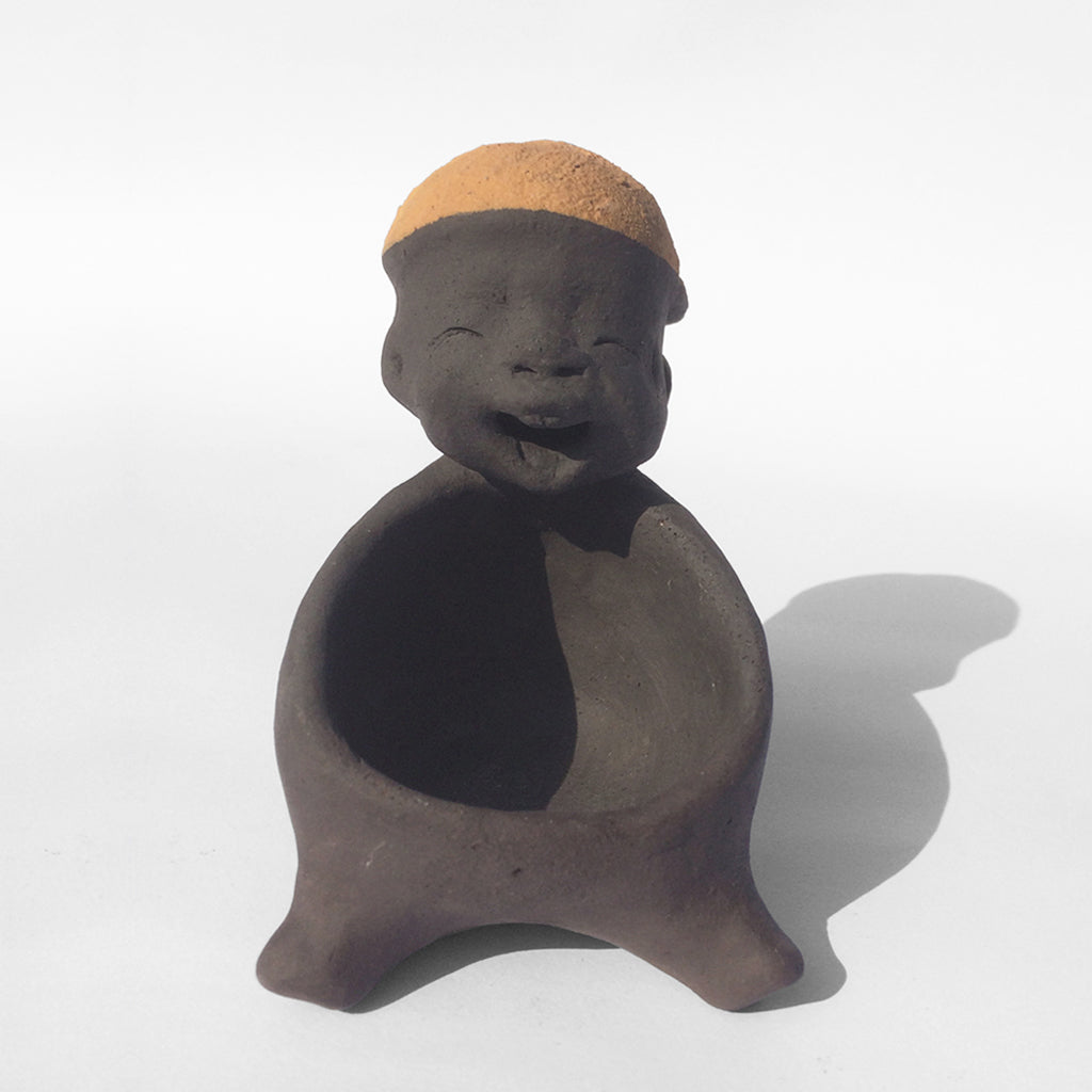 Dark grey ceramic figurine with orange cap.