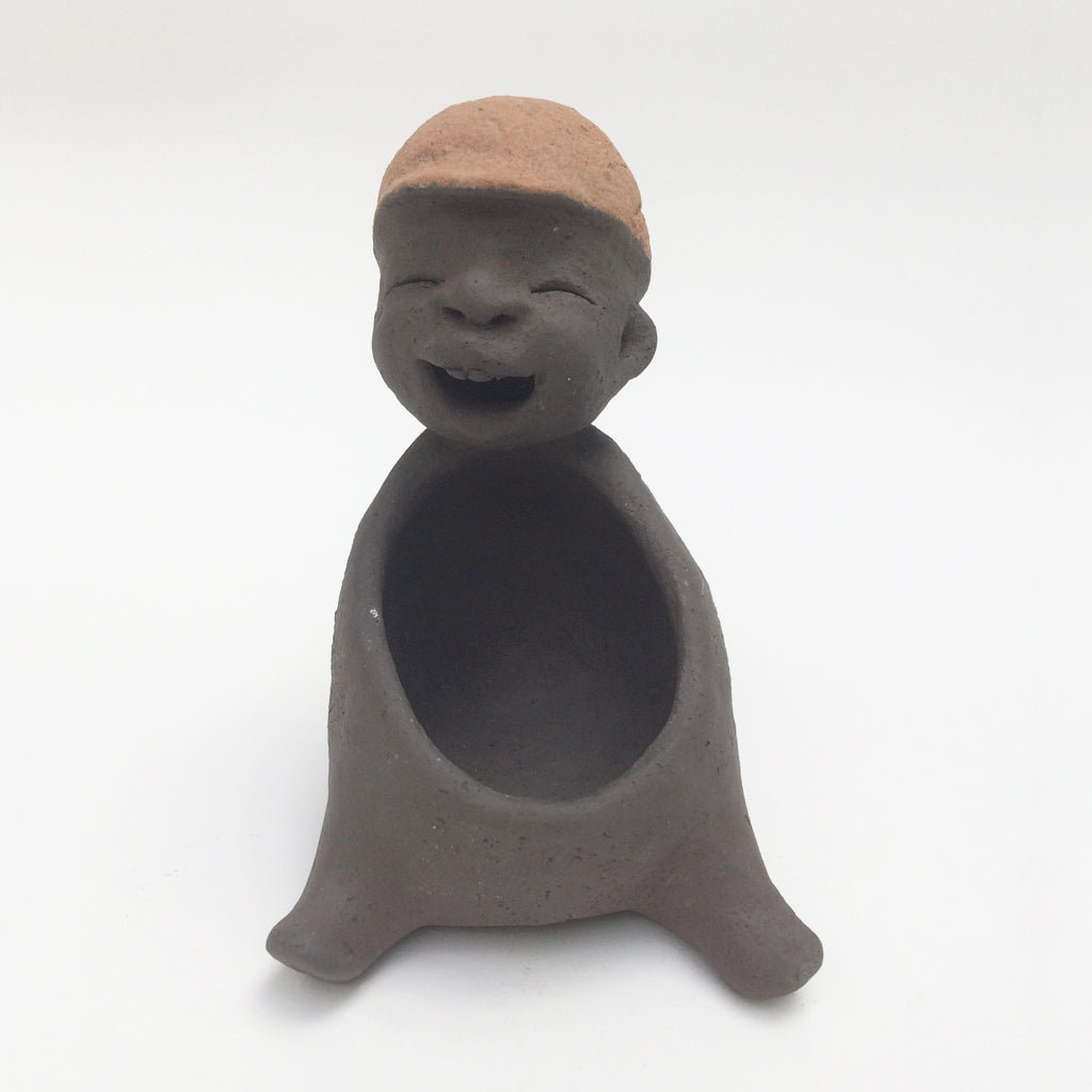Dark grey ceramic figurine with brown cap.