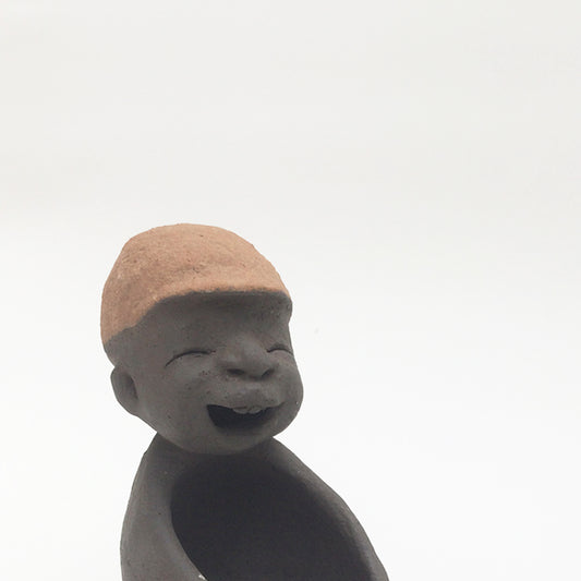 Dark grey ceramic figurine with brown cap.