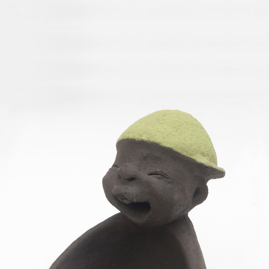 Dark grey ceramic figurine with green cap.