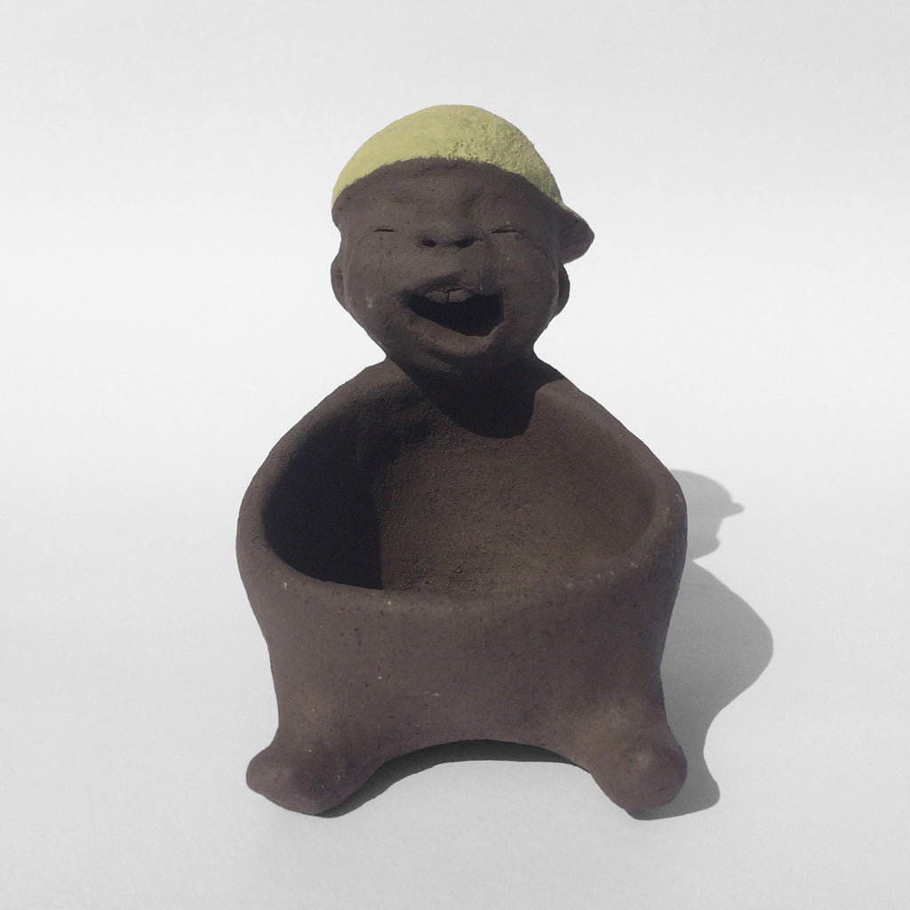 Dark grey ceramic figurine with green cap.