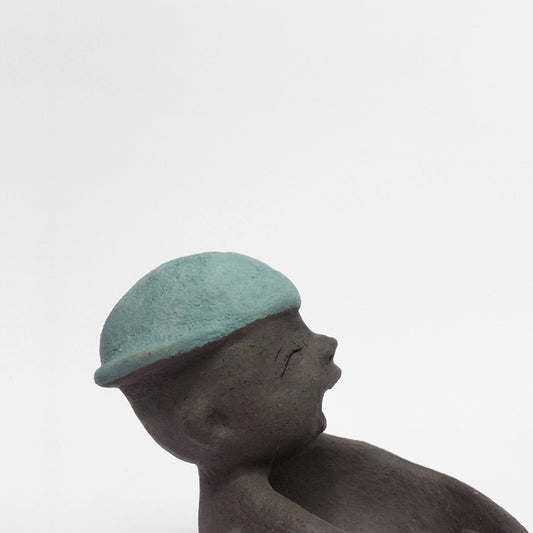 Dark grey ceramic figurine with blue cap.