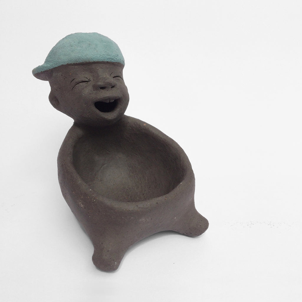 Dark grey ceramic figurine with blue cap.