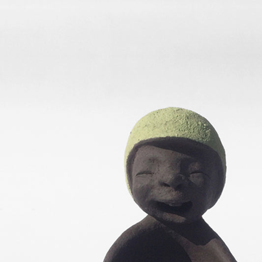 Dark grey ceramic figurine with green helmet.