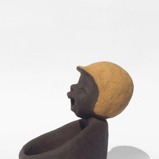 Dark grey ceramic figurine with yellow helmet.