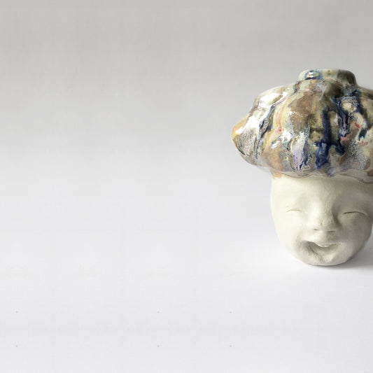 White figurative ceramic sculpture with abstract purple glazed head.