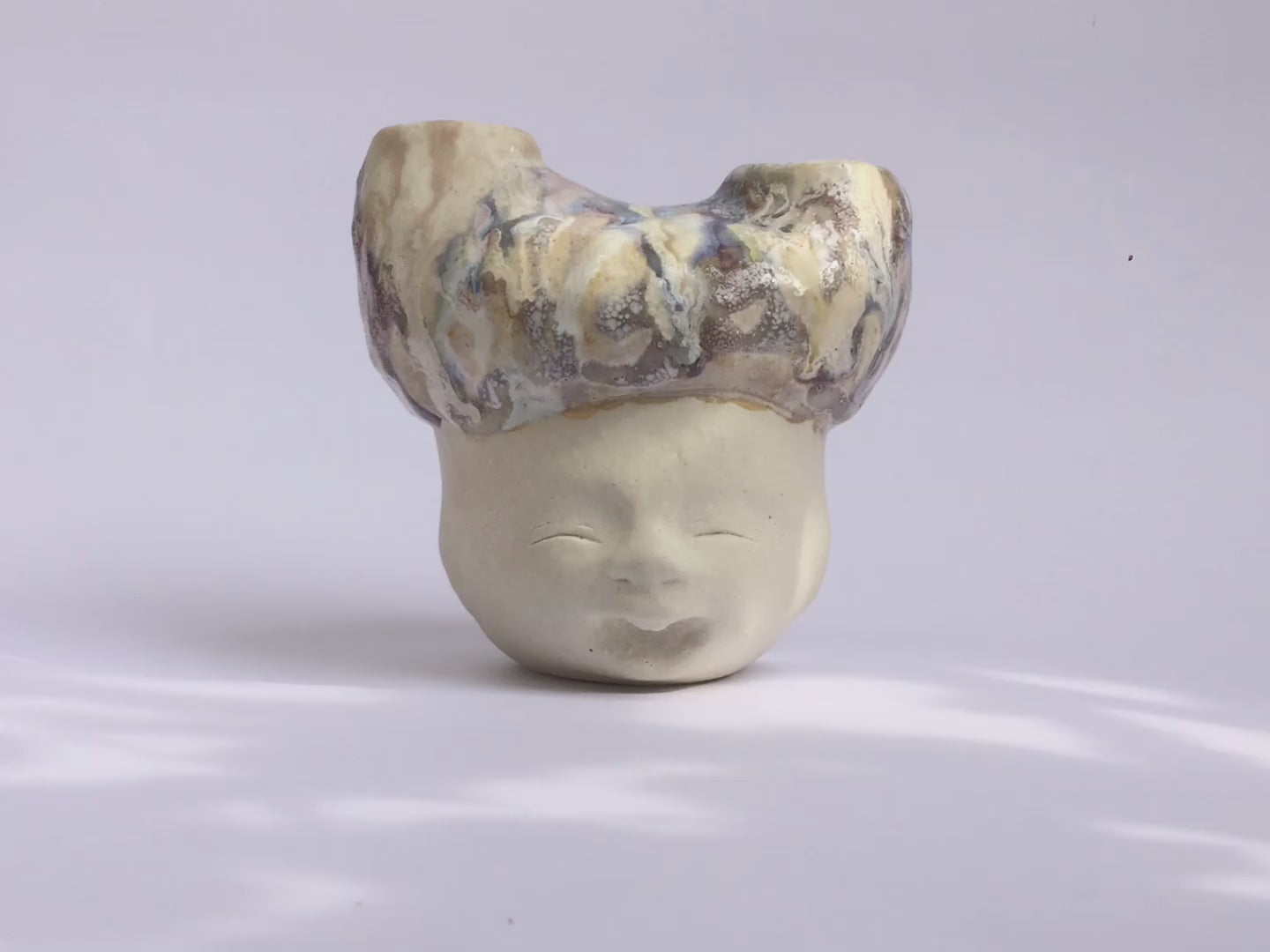 White figurative ceramic sculpture with abstract purple glazed head 360 video. 