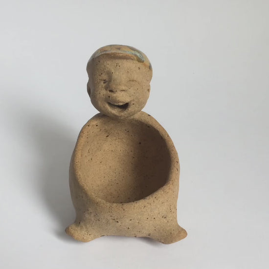 Video of brown unglazed figurative ceramic object with speckle glazed accent on top