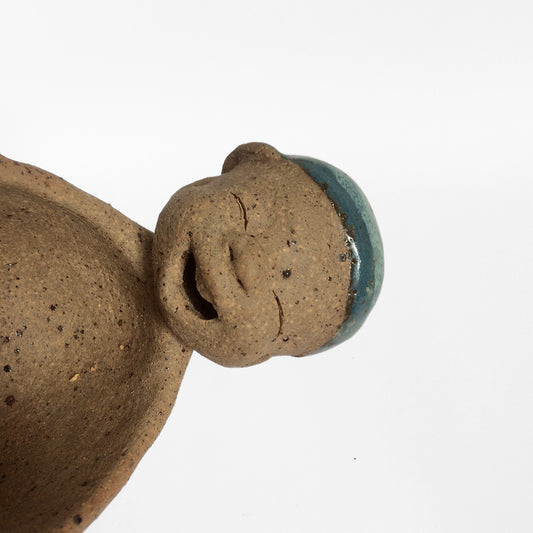 Brown unglazed figurative ceramic object with blue glazed accent 