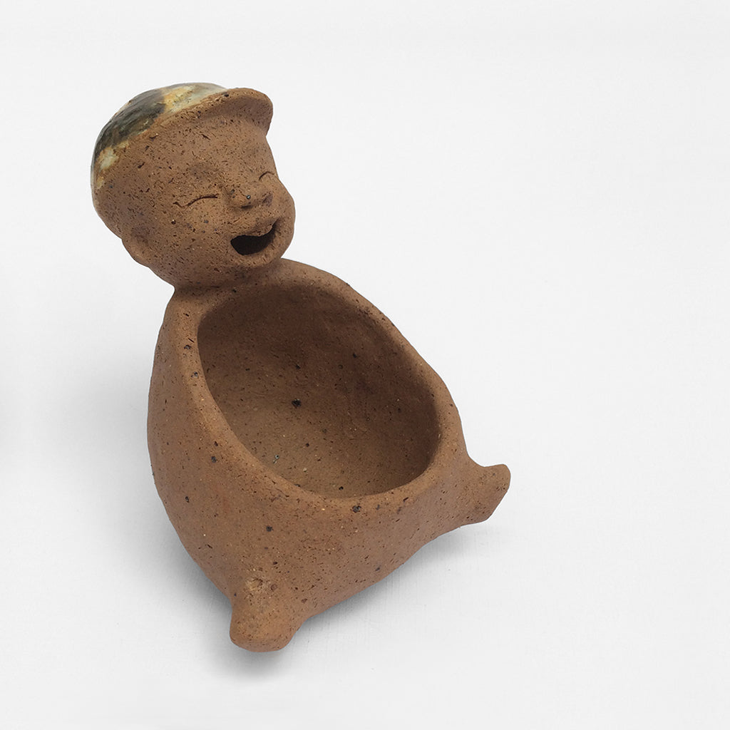 Brown unglazed ceramic object with speckle glazed accent on top.