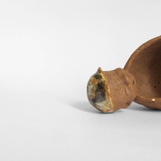Brown unglazed figurative ceramic object with speckle glazed accent