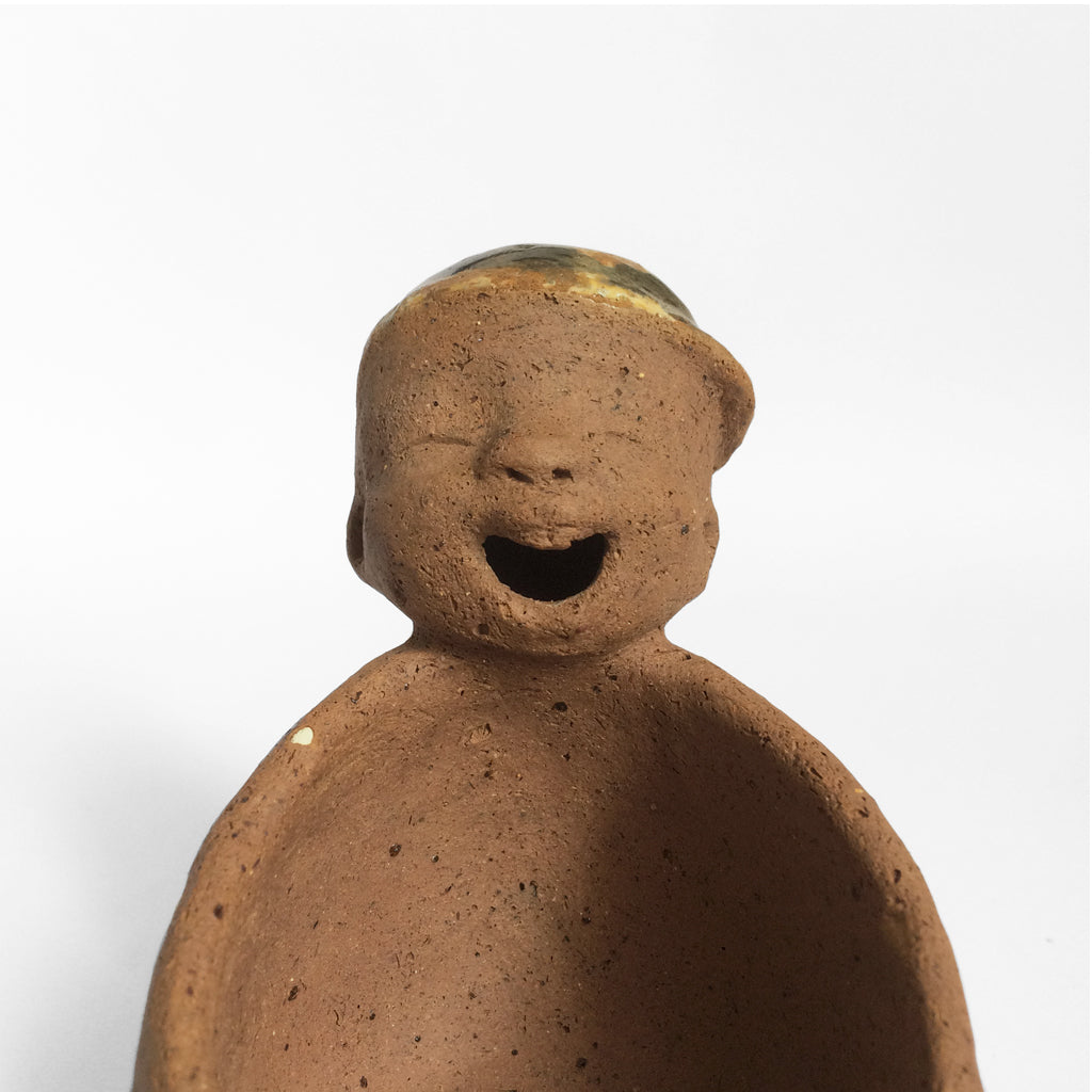 Brown unglazed figurative ceramic object with speckle glazed accent on top