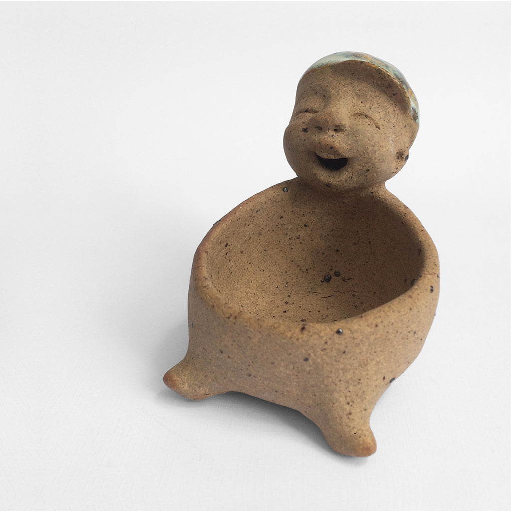 Brown unglazed figurative ceramic object with speckle glazed accent on top
