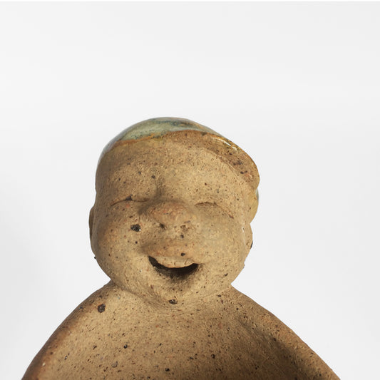 Brown unglazed figurative ceramic object with speckle glazed accent on top