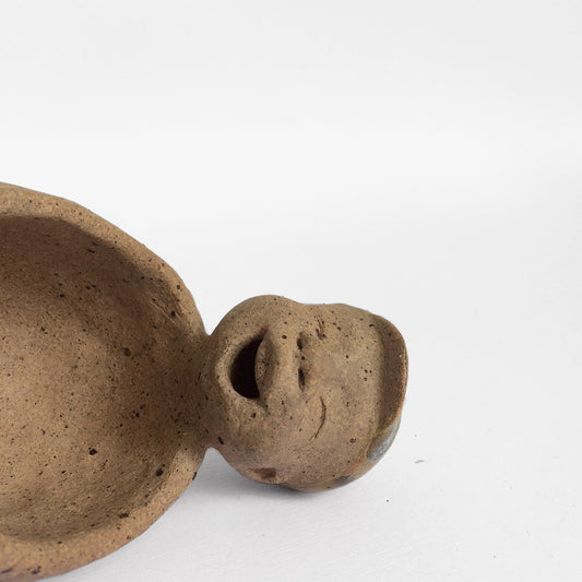 Brown unglazed figurative ceramic object with speckle glazed accent