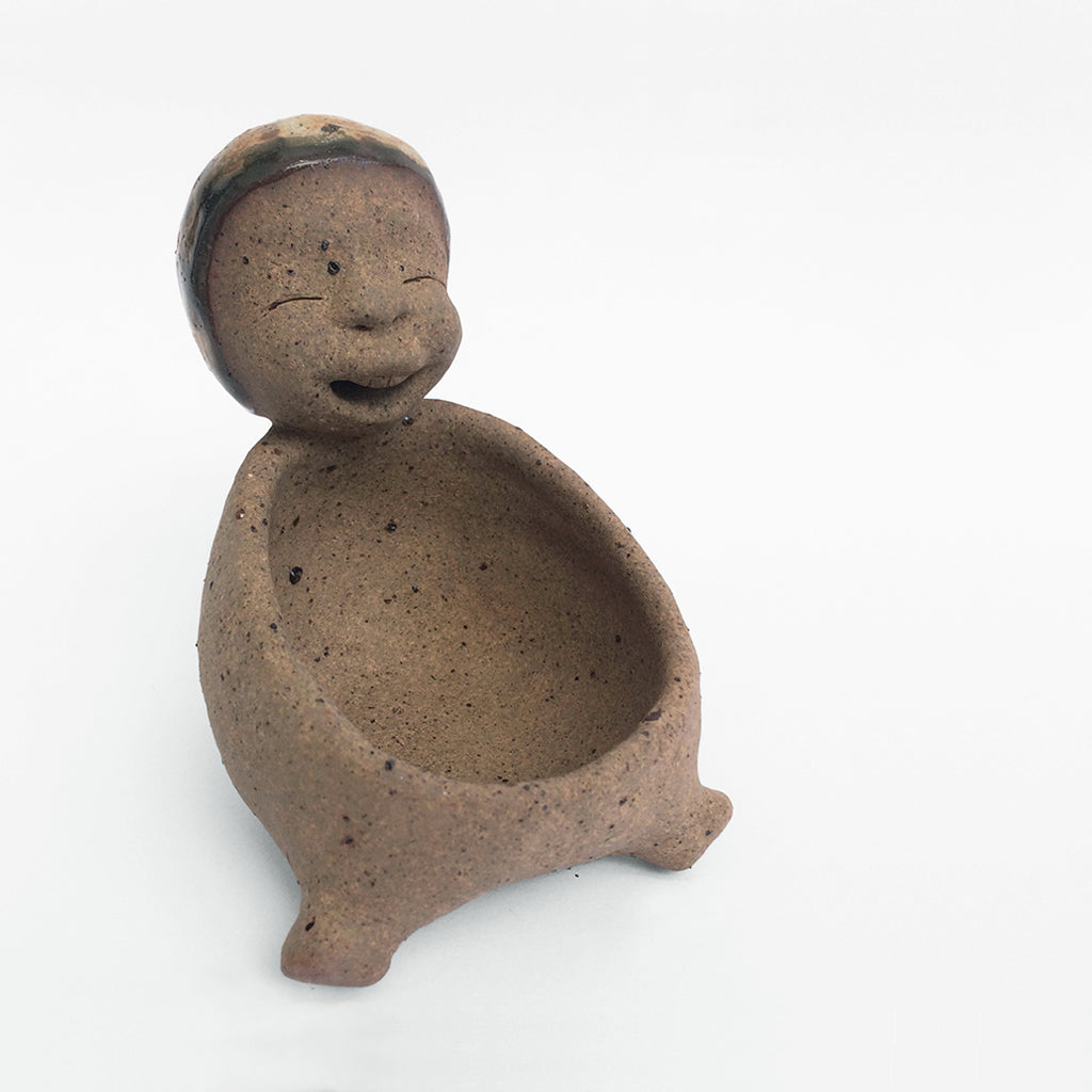 Brown unglazed figurative ceramic object with speckle glazed accent on top.