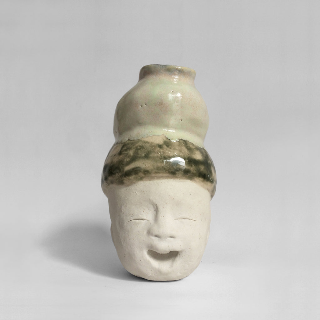 White figurative ceramic sculpture with mixed glazed head facing front.
