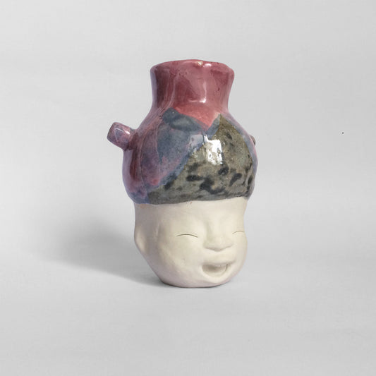 White figurative ceramic sculpture with mixed glazed head facing right.